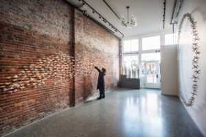 This exhibition shot includes 3 installations: 
'Kiss the Joy as it Flies': 400 geometric abstracted birds in flight across the brick wall (handbill and oxidation fired)
'The Skin We're In': 9 abstracted figurative sculptures  (thrown and crater glazed, 3ft tall each)
'A Speck of Dust' :  starry porcelain orbs installed as a 9’ buoyant shimmering circle.

Photo credit: Cathie Ferguson