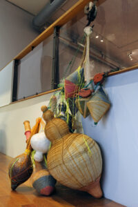 Materials: Hand built Earthenware, Porcelain, Stoneware, Woven Electrical Wire, Knit and Crocheted Fishing Line, Handmade paper pulped from Upcycled Old Clothes (Denim, Cotton, Linen) and Plants (Flax, Dahlia), Antique Hooks, Rust Dye