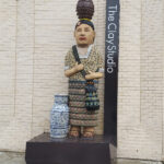 Outdoor sculpture greeting visitors near the entrance of The Clay Studio of Philadelphia. The figure is carrying three vessels representative of the communities where the new clay studio building is located.