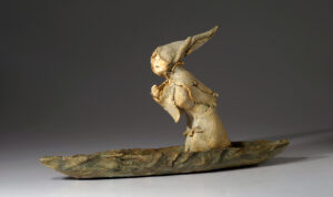 Little figure with a hat on a boat
