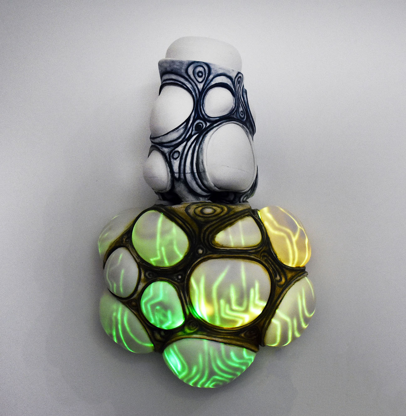 A ceramic container with a lid sits on top of a glowing shelf. LED lights, a sound sensor, and a power cable are hidden on the interior of the shelf. When exposed to sound, the shelf glows brighter, changes color, and flickers, allowing the hidden circuit board pattern to be displayed.
