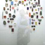 small representational objects in a halo on a white wall