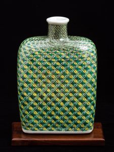 The Woven Bourbon Bottle was press-molded and gas reduction fired. Hand-painted gucai over-glaze enamels were electric fired. Enamels were built up abstractly to highlight the inherent luminosity and tactile qualities of the transparent over-glaze media.