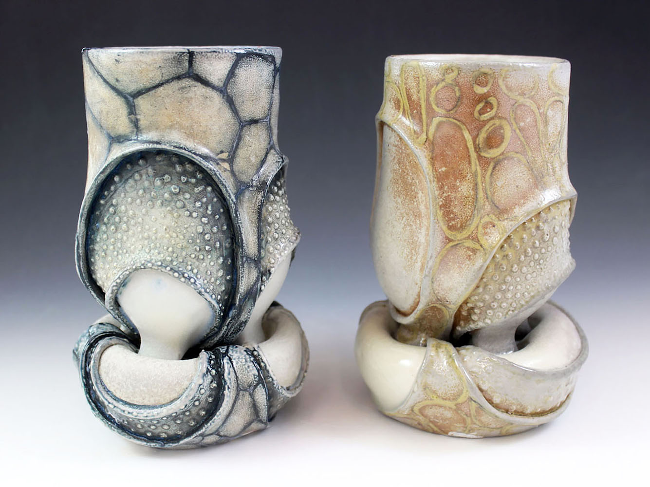 Wheel-thrown functional mugs sit on top of mini platforms that flip over to become functional bowls. Fired in a soda/wood kiln.