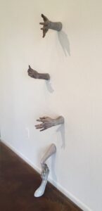 The hands reaching from the wall, are for those looking for connection and to break through to a new reality. Clasping hands from floor and wall indicate it is possible to find that support and connection. This is a reaction to border wall and those so much in need and can be felt on many levels.