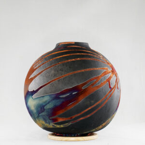 The copper matte glaze is only applied to a portion of the vase, resulting in its body being half-covered in a beautiful unexpected rainbow-like metallic finish after Raku firing. Every vase is guaranteed to be one of its kind, almost effortlessly accenting the very shape of the vase.