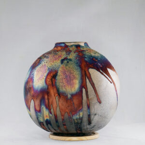 The copper matte glaze is only applied to a portion of the vase, resulting in its body being half-covered in a beautiful unexpected rainbow-like metallic finish after Raku firing. Every vase is guaranteed to be one of its kind, almost effortlessly accenting the very shape of the vase.