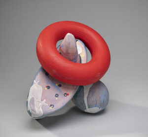 Abstract sculptural object with a large red ring dangling from a horn.