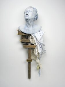 Full materials list: Earthenware, dining room chair, handmade doily, hospital gown, teddy bear, oxygen tubing, underglaze, wax