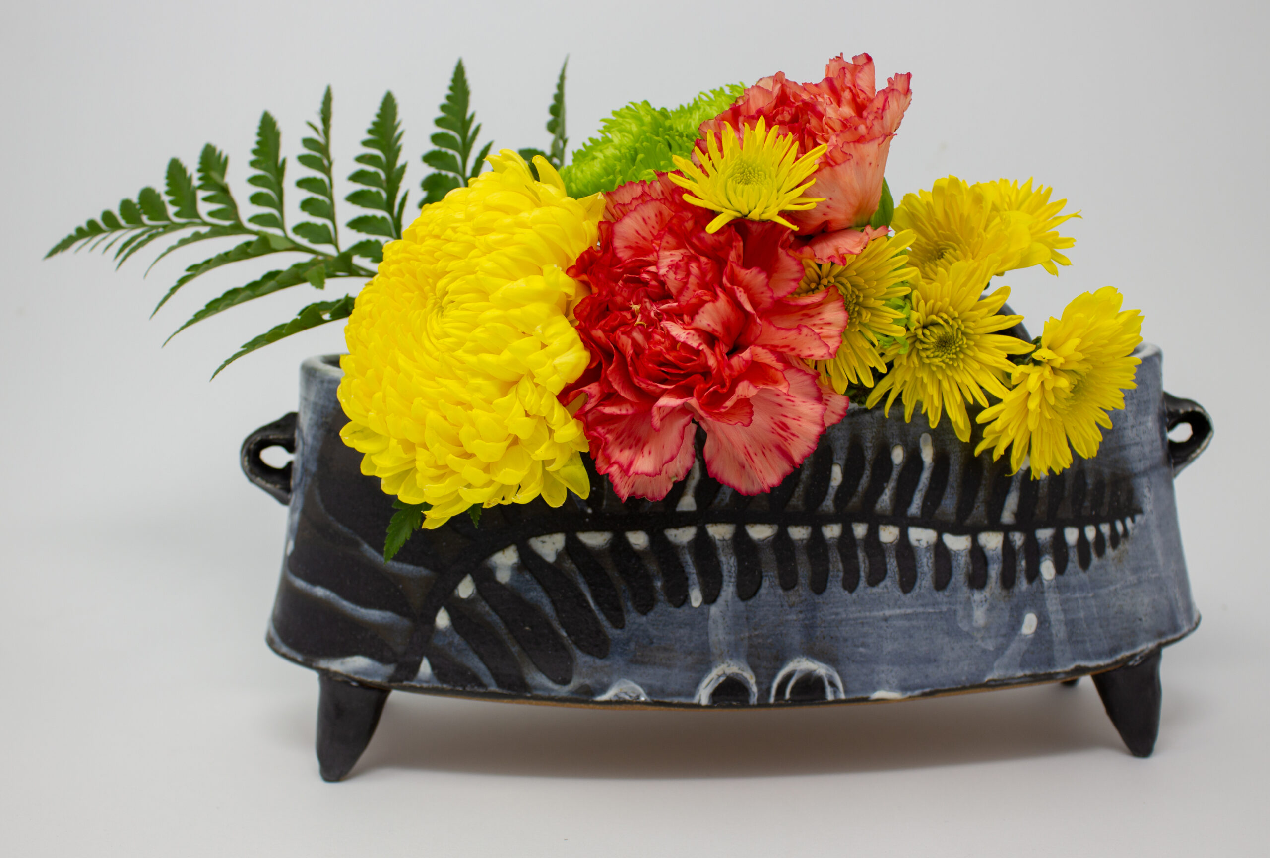 All pieces are dipped in slip, bisque fired, hand painted with wax resist designs, and dipped in a contrasting slip.