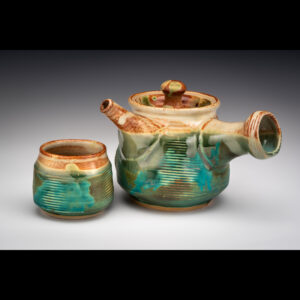 Teapot and yunomi are thrown and altered by paddling after throwing. Kyusu handle and spout  are thrown separately and added after trimming foot. Teapot and yunomi are white stoneware and fully functional. Teapot has strainer holes under the thrown spout and steam hole in lid. They are microwave and dishwasher safe.