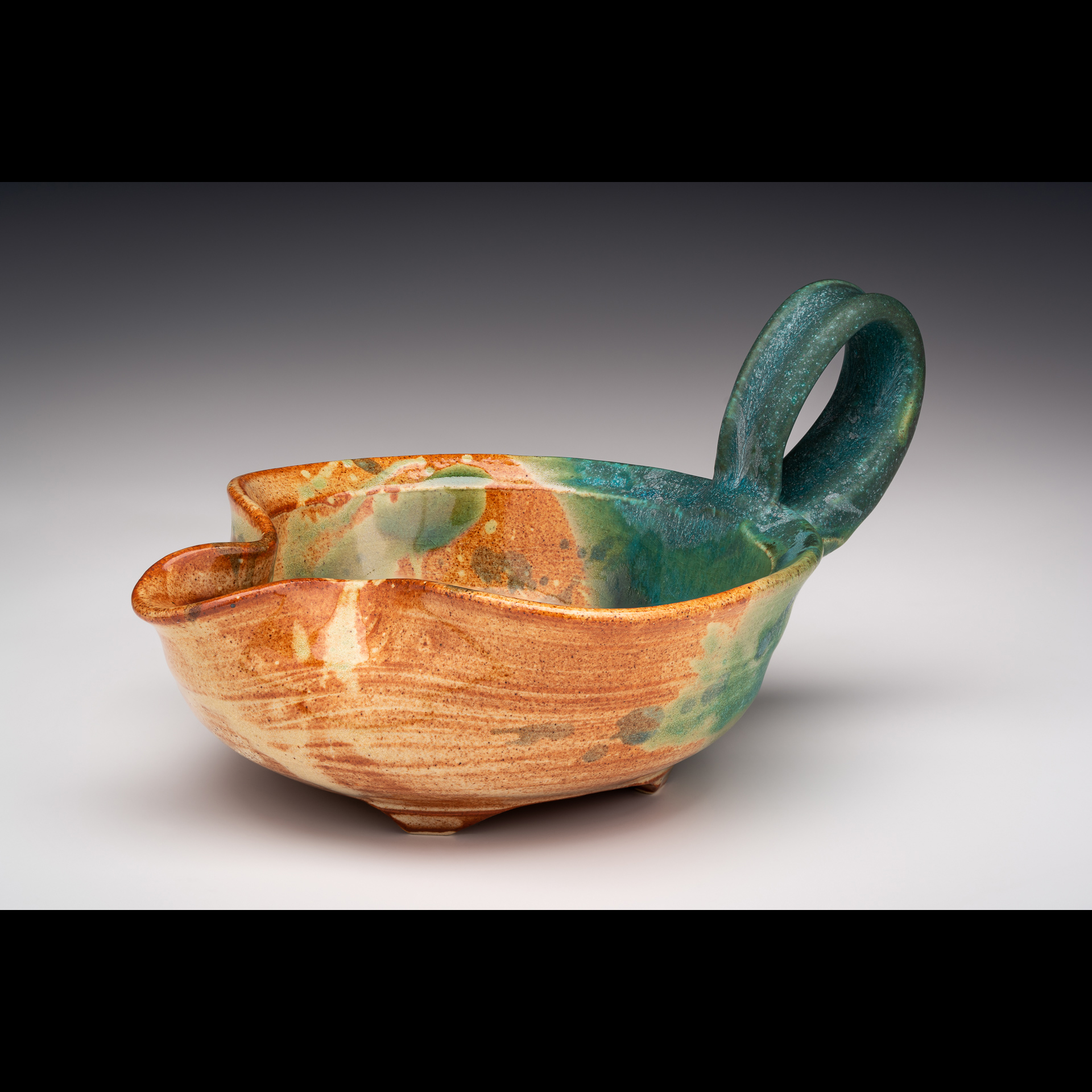 Stoneware mixing bowl is thrown, with pulled spout and pulled handle. Fired to Cone 6 in oxidation with non commercial glazes/shino and turquoise glazes hand mixed by me. Other glazes splashed on top. Foot is trimmed and then carved.