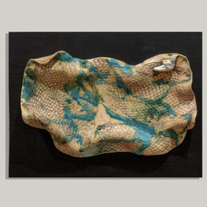 This wall piece titled "Free Bird" has a pinched stoneware bird attached to a highly textured slab. The little bird is totally glazed white with yellow beak and is contrasted by the rolled and textured slab background that is stained and sparsely glazed to emphasize contrast. The piece is attached to a piece of painted black wood that is wired on the back to hang on the wall.