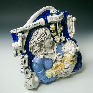 After enjoying an inspiring exhibition at the Boston Museum of Fine Arts on Della Robbia's work in 2016, I tried to figure out how I might work in this Majolica technique—having just become a grandmother, as seen in this image. I painted a brown underglaze into the details. After bisque firing, majolica glaze colors were applied, and I scratched away at the details to reveal the brown line. I love the majolica process, as you can see what you are doing the whole time instead of covering the underglaze colors with clear glaze.