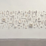 300 objects utilizing a range of ceramic technique, arranged in a free form display made of porcelain recreations of found objects sourced from my surroundings. They were selected to represent influences from the places I've lived, people I've encountered, and items that possess a personal aura. I utilize mold making primarily for its ability to borrow from the world and arrange them within a modular configuration for the audience to freely associate relationships and connections through memory, oscillating between universal and specific.