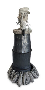 Top of sculpture rotates slowing (on an electric  turnstyle). Option of audio track: Distortion of President George Bush giving Mission Accomplished speech over Osama Bin Laden's Call to Jihad speech.