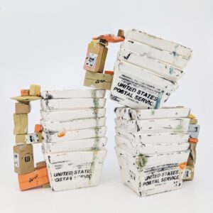Carly Slade, Porcelain ceramic mugs. Three ceramic mugs made from miniature USPS main bins. The mug handle is sculpted from a stack of packages and letter mail.