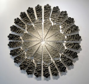 These tiles are slip cast. I create my molds by 3D printing prototypes that I cast plaster molds around. My designs are created in Rhino by using a heightfield image, translating a photograph into virtual surfaces that I digitally sculpt into tile forms. This piece hangs on custom 3D printed hardware.