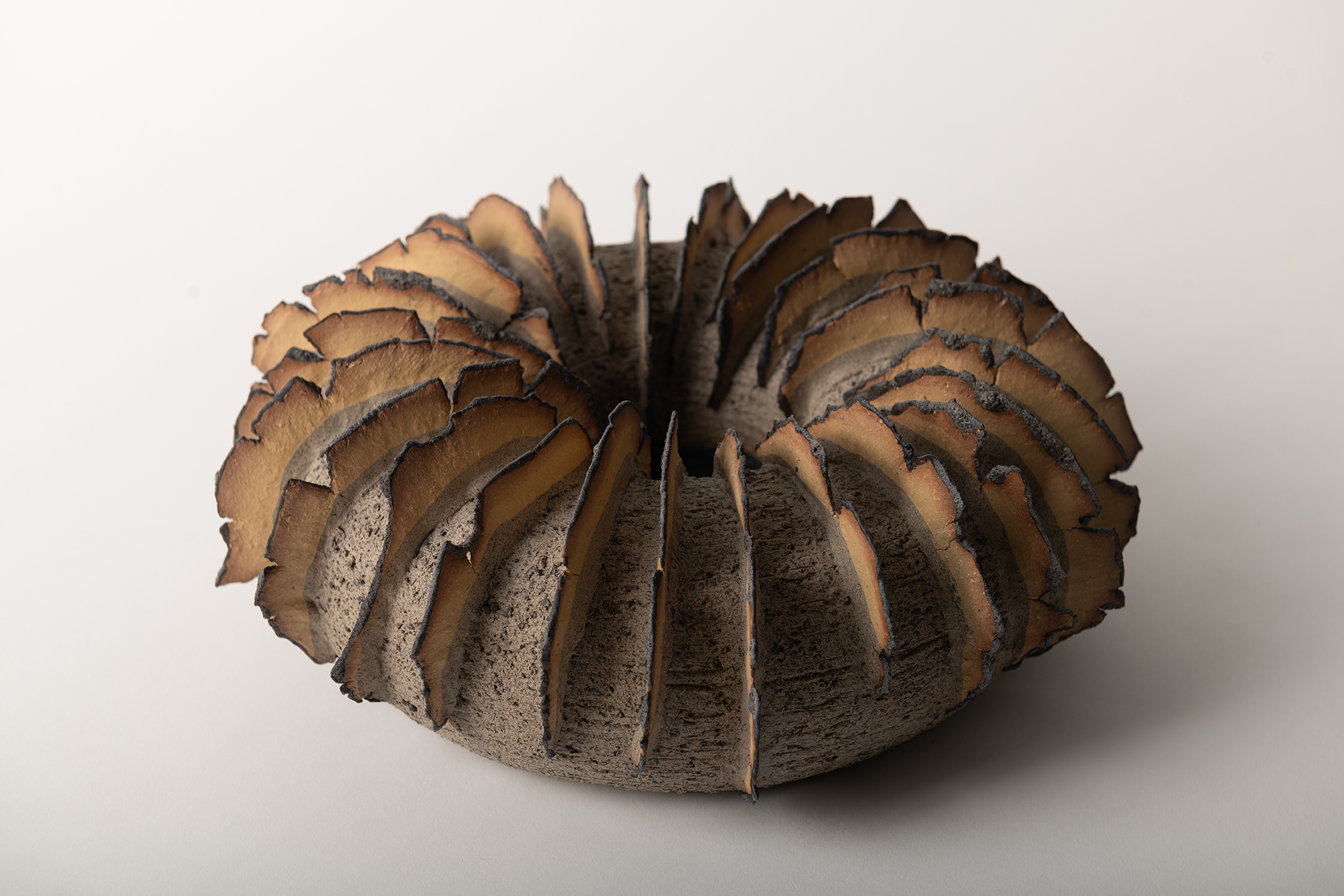 The volcanic glaze is brushed on the texturs  edges. Gray & yellow clay