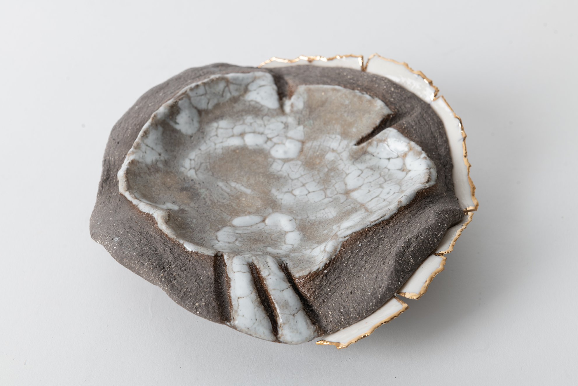 Gray  stoneware combined with porcelain, decorated with gold luster.