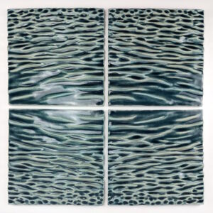 The tiles were created by pressing clay onto molds and altering by hand. I create my molds by using a CNC to carve them, or 3D print prototypes that I cast plaster molds around. My designs are created in Rhino by using a heightfield image, translating a photograph into virtual surfaces that I digitally sculpt into tile forms.
