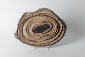 The layers are built from gray and yellow clay . volcanic and crackle glazes decorated with gold luster