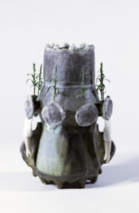 This piece represents what I see driving through most midwestern states in the U.S. The dexterity in her arms and hands (the original tool of farming) have been limited by her dress. Subsistence in the form of corn grows from her breasts. Her feet, like roots, grow down into the earth. She wears a crown.