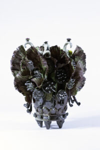 The vessel depicts different elements from an agrarian perspective. It includes compost from our farm solidified in resin and permanently attached to the piece.