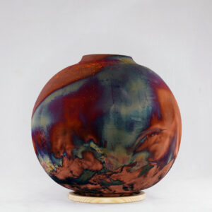 The full copper matte glaze provides a striking finish to the vase, making it an instant contrast to any interior. With an iridescent splash of metallic-like colors and unique patterns covering the vase’s body after Raku firing, no two pieces are the same.