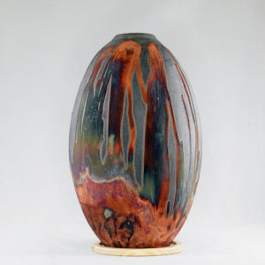 The copper matte glaze is only applied to a portion of the vase, resulting in its body being half-covered in a beautiful unexpected rainbow-like metallic finish after Raku firing. Every vase is guaranteed to be one of its kind, almost effortlessly accenting the very shape of the vase.