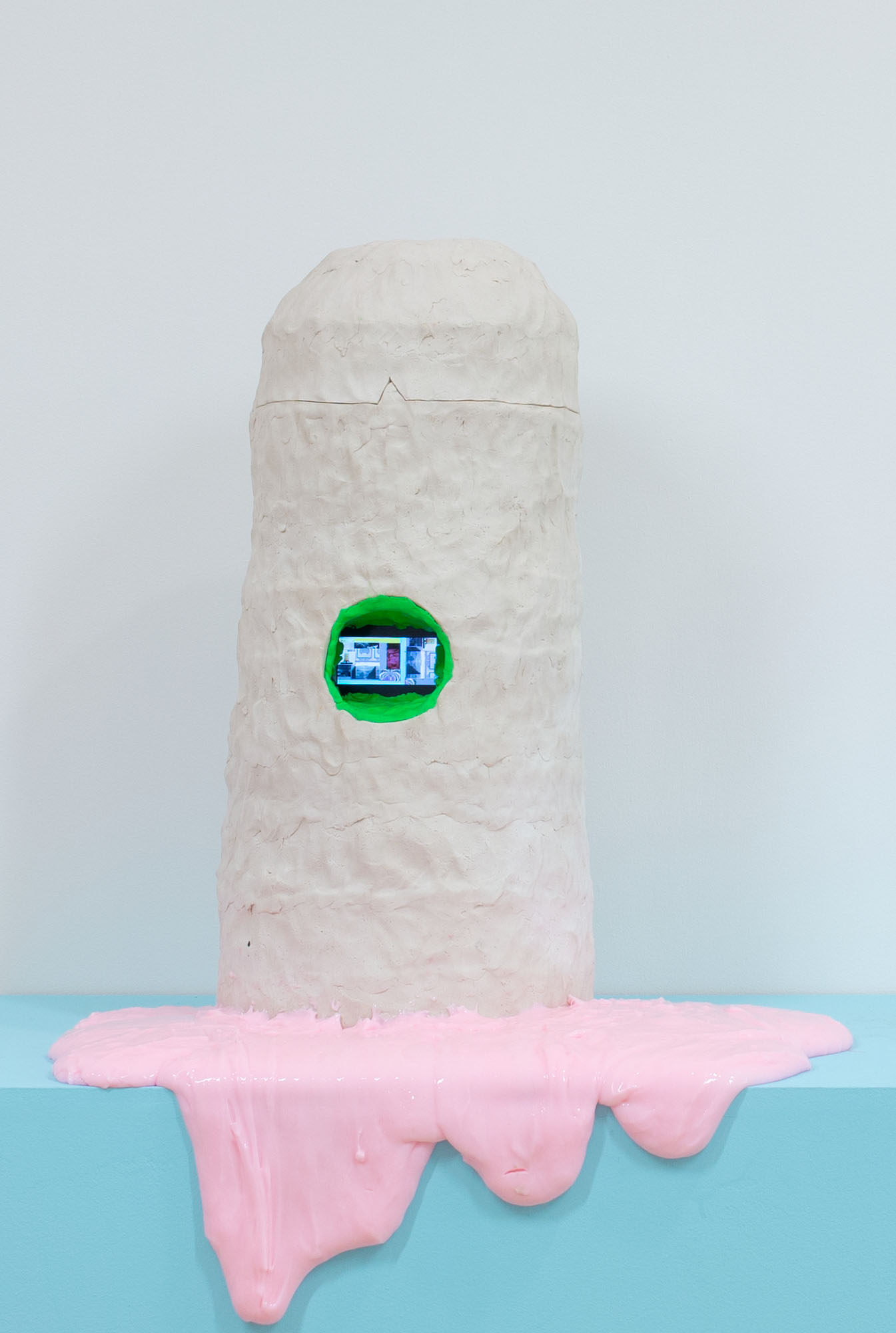pink polymer slowly oozes out of sculpture while video embedded in the sculpture loops.  
Full video length is 20 minutes.  Layered in it is time lapse documentation of several ceramic sculptures oozing a substance over a 24-48 hour period.  The white ceramic sculpture in the video is also the sculpture the video is embedded

video clip can be found here: https://vimeo.com/263821343