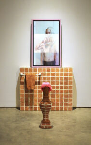 2020, Video, TV, Terracotta, Bathroom towel rack, rhinestones, wig, glitter, grout 

This installation helped me begin think about the importance of reflection and examination, and the bathrooms place as the proverbial “closest” and its necessity in the queer experience. It also began my exploration and understanding into identity signifiers. It posed the question: what happens to an identity if one of the “main” signifiers is removed.