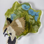 wall hanging sculpture of a ceramic bird and fabric map